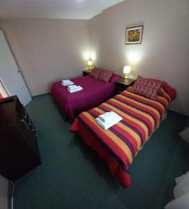 a hotel room with two beds and a television at My House in El Calafate in El Calafate