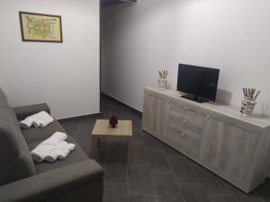 ein Wohnzimmer mit einem Sofa und einem Flachbild-TV in der Unterkunft La casa di Ornella in Avola