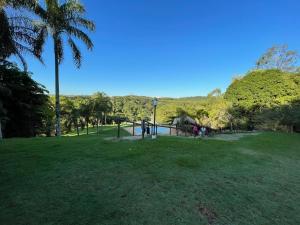 un parc avec une aire de jeux et des palmiers dans l'établissement Chácara linda em condomínio rural - Sousas, à Campinas