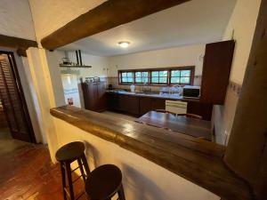 eine Küche mit einer Theke und Hockern in einem Zimmer in der Unterkunft Chácara linda em condomínio rural - Sousas in Campinas