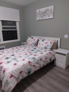 a bedroom with a bed with a floral bedspread at brighton beach rooms in Brooklyn