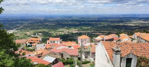a view of a town with roofs and buildings at Refúgio d’Aldeia da Serra in Seia