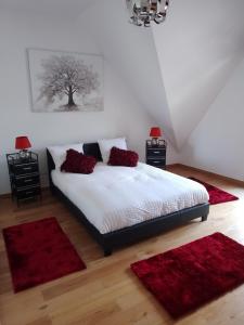 a bedroom with a bed with two red rugs at Résidence Les beaux jours in Neufchâtel-Hardelot