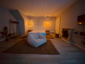 a living room with a white bed and a white chair at Casa do Sol in Aveiro