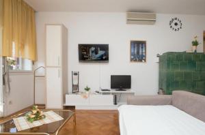 a living room with a couch and a tv at Apartments Oršula in Split