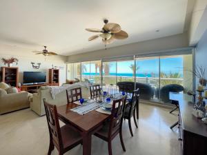 a living room with a dining room table with a view of the ocean at Upscale Beachfront Condo with Tub and Private Beach in Playa Encanto
