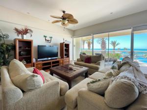 a living room with two couches and a flat screen tv at Upscale Beachfront Condo with Tub and Private Beach in Playa Encanto