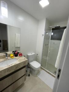 a bathroom with a toilet and a sink and a shower at Apartamento na Praia dos Anjos in Arraial do Cabo