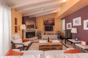 un soggiorno con un divano e una TV di Panoramic view!Penthouse 120qm of sea & mountain a Loutra Edipsou