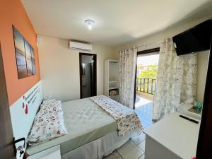 een kleine slaapkamer met een bed en een balkon bij Pousada Mar e Paz in São Francisco do Sul