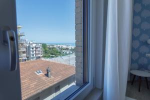 a window with a view of a roof at Vista Mare Guest House in Civitanova Marche