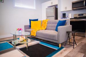 uma sala de estar com um sofá e uma mesa em AIR & ROAD TRAVELERS' PERFECT SPOT! + FULL KITCHEN em Regina
