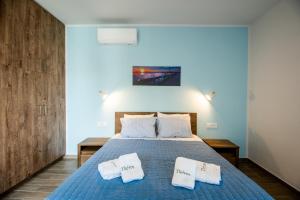ein Schlafzimmer mit einem blauen Bett mit zwei weißen Kissen in der Unterkunft Thèros garden in Istro