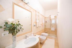 uma casa de banho com um lavatório, um WC e um espelho. em B&B Calamoresca em Àrbatax