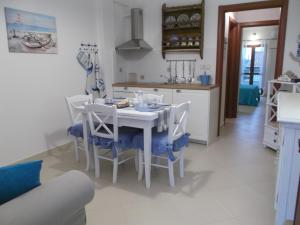 cocina y comedor con mesa blanca y sillas en L'Ancora suite, en Orosei