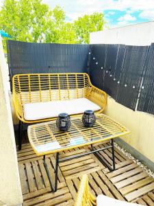 uma cadeira amarela e uma mesa num pátio em Charme et Douceur By UTA HOUSE em Saint-Denis