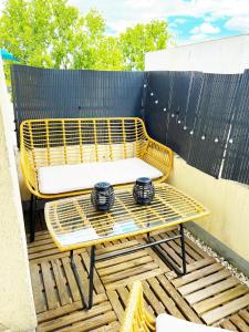 a yellow chair and a table on a patio at Charme et Douceur By UTA HOUSE in Saint-Denis