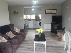 a living room with a couch and a table at Sea breeze Cottage in Dungloe