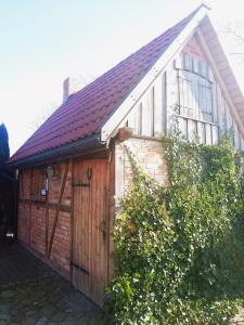 a wooden garage with a red brick building at Villa Akacja in Łeba