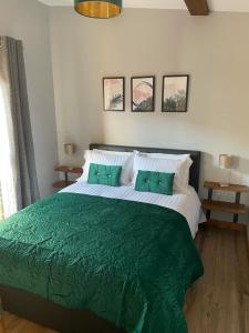 a bedroom with a large bed with a green blanket at The Hide in Ullapool