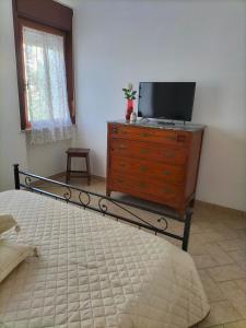 1 dormitorio con cama y vestidor con TV en APPARTAMENTO DI VIA REFINI II, en Spoleto