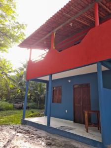 une maison bleue et rouge avec un toit rouge dans l'établissement Axe Mainha Flats e Kitnet, à Morro de São Paulo