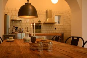 una cocina con una mesa de madera y una lámpara. en Grevlunda skola, en Vitaby