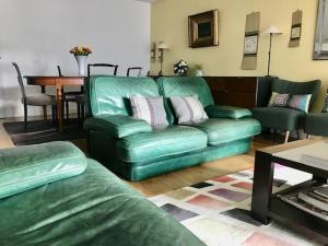 - un salon avec un canapé vert et une table dans l'établissement Le Bouscat: un superbe appartement en résidence, à Le Bouscat