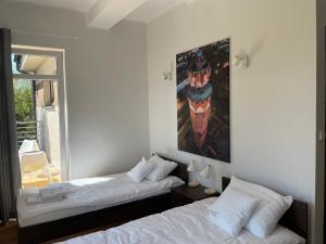 - une chambre avec 2 lits et un tableau mural dans l'établissement Wojtas Entree Apartments, à Brodnica