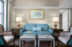 a living room with a blue couch and two chairs at The Royal Sonesta Chase Park Plaza St Louis in Saint Louis