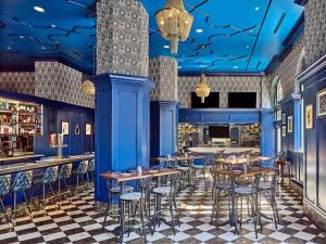 a restaurant with blue walls and tables and stools at The Royal Sonesta Chase Park Plaza St Louis in Saint Louis