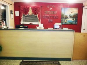 a reception desk in a room with a red wall at DeQueen Courtyard Inn in De Queen