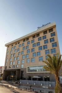 斯法克斯的住宿－Radisson Hotel Sfax，一座大建筑,前面有棕榈树