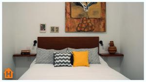 a bedroom with a bed with yellow and grey pillows at Cozy Apartment close to Andares @serra in Guadalajara