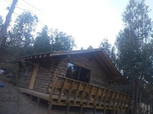 a log cabin in the woods with a large window at Estancia Don Domingo in Curicó