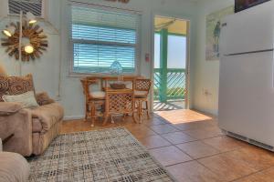 - un salon avec un canapé, une table et un réfrigérateur dans l'établissement Chateau 8W, à Clearwater Beach