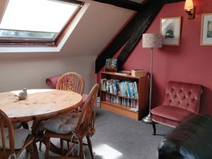Habitación con mesa, sillas y estante para libros. en The Coach House, en Bridgwater