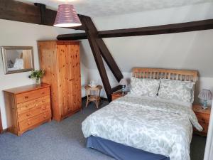 ein Schlafzimmer mit einem großen Bett und Holzmöbeln in der Unterkunft The Coach House in Bridgwater
