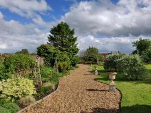 un camino en un jardín con árboles y arbustos en The Coach House, en Bridgwater