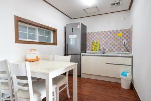 a small kitchen with a white table and chairs at White dream Pension in Jeju