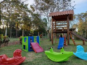 a playground with colorful play equipment in the grass at Pousada Casa do Bosque in Penedo