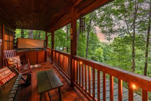 um alpendre com uma televisão de ecrã plano em Secluded Sunrise Ridge-10 Min From Blue Ridge, King Beds, Hot Tub, 2 Porches, Fireplace Wood Burning, Mountain View, Cozy em Blue Ridge