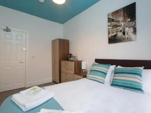 a bedroom with a white bed with towels on it at Townhouse @ Westminster Street Crewe in Crewe