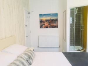 a white bedroom with a bed and a window at Townhouse @ Westminster Street Crewe in Crewe