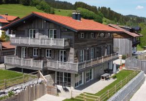 una gran casa de madera con techo rojo en Kräuterhof Chalets, en Missen-Wilhams