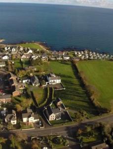 an aerial view of a neighborhood with houses and the ocean at Glendale Bed and Breakfast, Cushendall in Cushendall
