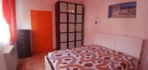 1 dormitorio con cama y puerta de color naranja en locazione mimosa con giardino, en Ostellato