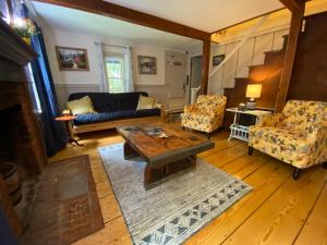 ein Wohnzimmer mit einem Sofa, einem Tisch und Stühlen in der Unterkunft Romantic, Secluded Historic Cottage on 5 Acres 30 mins to TIEC in Landrum