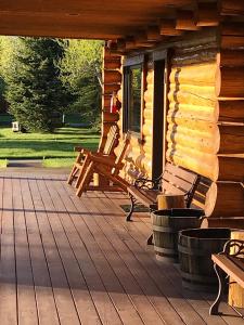 a porch of a log cabin with benches on it at Teton Cabins in Moran