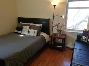 a bedroom with a bed and a table with a lamp at Most Economical Room in Center Washington DC in Washington, D.C.